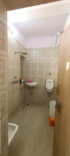 a bathroom with a sink and a toilet and a urinal at Rajawat house in Tonk City