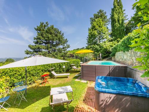 a backyard with a swimming pool and an umbrella at Holiday Home Ridaldi by Interhome in Lamole