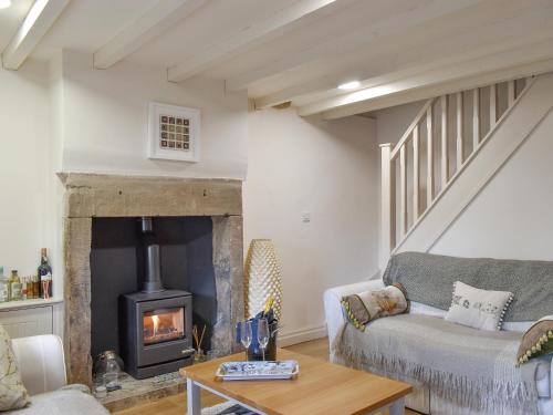 a living room with a couch and a fireplace at Easter Cottage in Bamford