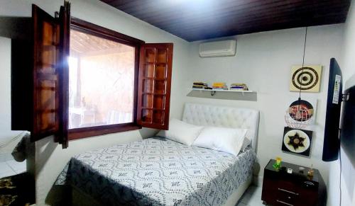 a small bedroom with a bed and a window at Cond CHACARA BAVIERA in Gravatá