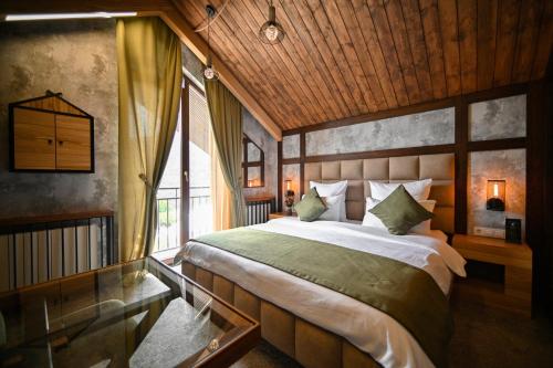 a bedroom with a large bed and a window at Escapes Boutique Hotel & Restaurant in Dilijan
