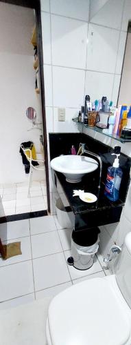 a bathroom with a white toilet and a sink at Cond CHACARA BAVIERA in Gravatá