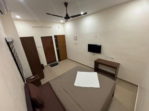 a room with a table and a flat screen tv at Casa Grand in Alwaye