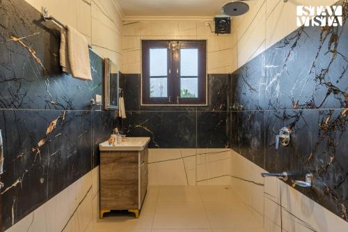 a bathroom with a sink and a window at StayVista at Lakeside Panorama with Lawn & Wi-Fi in Srinagar