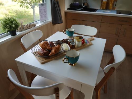 un tavolo con un vassoio di pane e dolci sopra di Tiny House avec vue sur le rocher de Saignon, Luberon a Saignon