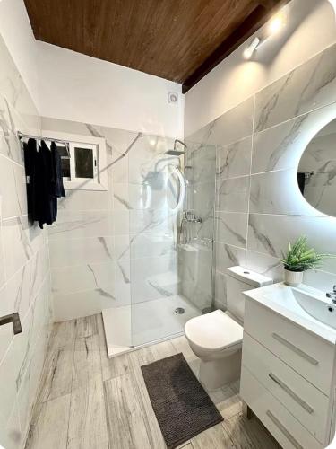 a white bathroom with a toilet and a sink at Casa Rural Encantadora Con Terraza Privada in Arona