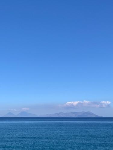 a large body of water with mountains in the background at B&B Xenia in Mongiove