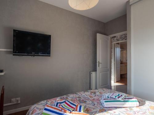 a bedroom with a bed with a flat screen tv on the wall at Holiday Home Chez David by Interhome in Kersaint-Plabennec