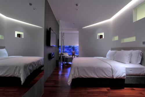 a hotel room with two beds and a desk at LiT BANGKOK Hotel in Bangkok