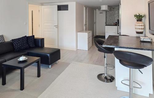 een woonkamer met een zwarte bank en een keuken bij 2 Bedroom Cozy Home In Skärholmen in Stockholm