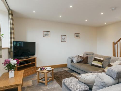 a living room with a couch and a flat screen tv at Applebarn - Uk10654 in West Pennard