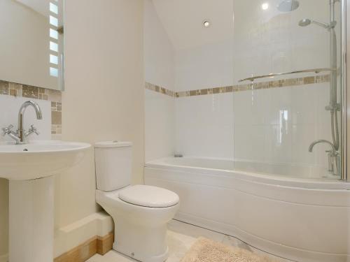 a white bathroom with a toilet and a bath tub at Applebarn - Uk10654 in West Pennard