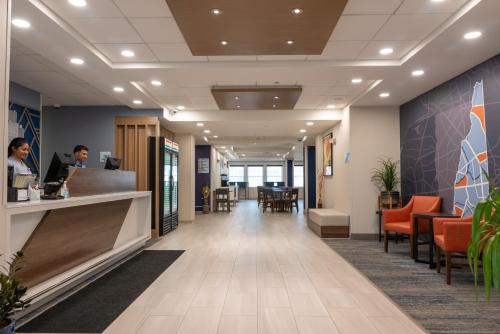 a lobby of an office with a woman at a counter at Holiday Inn Express Hotel & Suites Hampton South-Seabrook by IHG in Seabrook