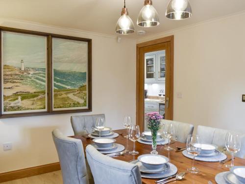 a dining room with a table and chairs and a painting at Stallion Barn in Crosby Garrett