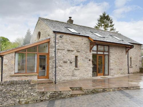 a stone cottage with glass doors and windows at Stallion Barn in Crosby Garrett