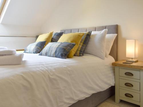 a bedroom with a bed with pillows and a night stand at Stallion Barn in Crosby Garrett