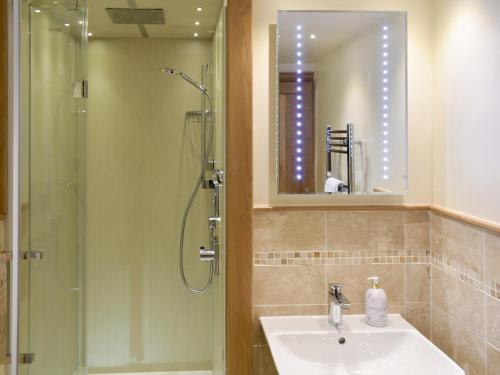 a bathroom with a sink and a shower and a mirror at Stallion Barn in Crosby Garrett
