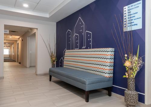 a blue bench in a hallway with a wall with a city at Holiday Inn Express Hotel & Suites Hampton South-Seabrook by IHG in Seabrook
