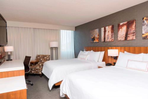 a hotel room with two beds and a television at Sonesta Hotel Grand Rapids Airport in Grand Rapids