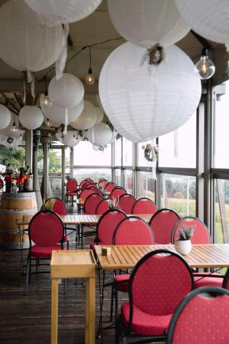 a room with tables and red chairs and white lanterns at Hotel & Restaurant Nollen in Hosenruck