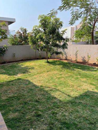 a garden with a tree in the middle of it at Luxury Villa with Private Garden in Dhamni