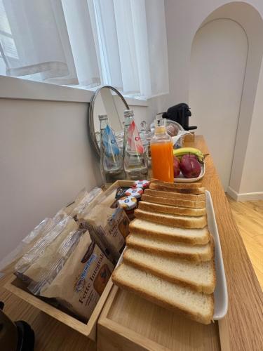 a sandwich on a wooden table with a plate of food at Cielo B&B in Crotone