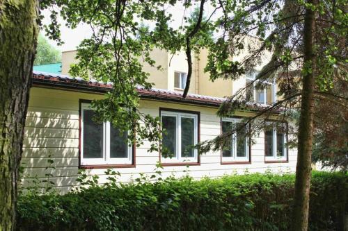 Ośrodek Wczasowy Mega - pokoje przy promenadzie في كولوبرزيغ: بيت ابيض شبابيك واشجار