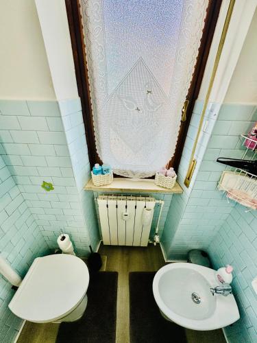 a bathroom with a toilet and a sink at Appartamento Lana zona terme Centro e vicino a Villa Igea in Acqui Terme