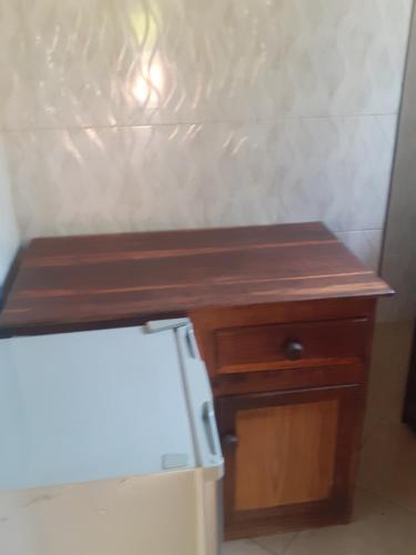 a small wooden table next to a refrigerator at Cannan stay in Livingstone