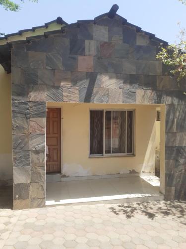 a house with a stone wall at Cannan stay in Livingstone