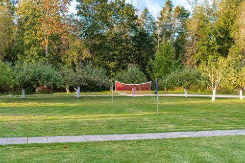 a park with a net in the grass at Namas su vaizdu į ežerą "Giliaus Nendrė" in Tytuvėnai