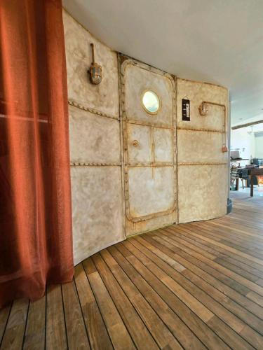 a room with a wooden floor and a red curtain at Cosicocoon in Port-Vendres