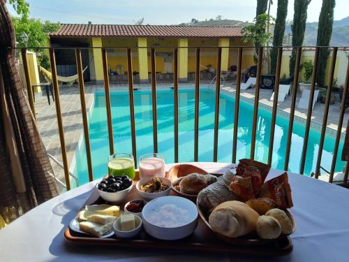 a tray of food on a table next to a pool at Hotel e Pousada Ciconha-são Lourenço MG in São Lourenço