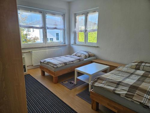 a room with two beds and a table and windows at Ferienwohnung 75m² bis 5Personen 2 SZ Frankfurt(Oder) in Frankfurt/Oder