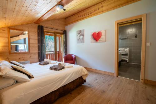 sypialnia z dużym łóżkiem i łazienką w obiekcie Chalet Clemalou 14-15 Personnes w mieście Châtel