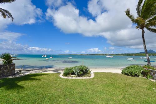 a view of a beach with boats in the water at Turquoise Bay Beach Apartments Trou d'Eau Douce in Trou dʼ Eau Douce
