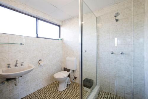 La salle de bains est pourvue de toilettes, d'un lavabo et d'une douche. dans l'établissement Villa Noosa Hotel, à Noosaville