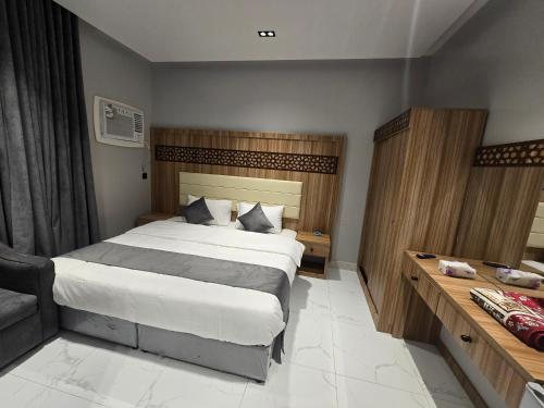 a bedroom with a large bed and a desk at شقق المطار in Jeddah