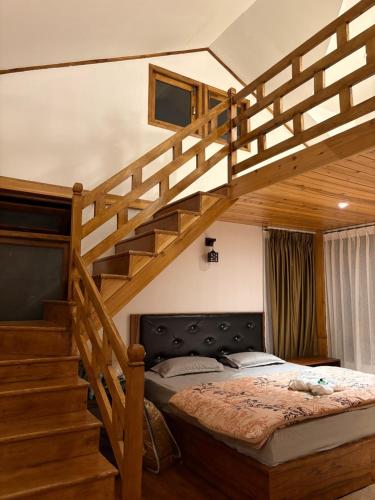 a bedroom with a loft bed and a staircase at Singyang Heritage Homestay in Pelling