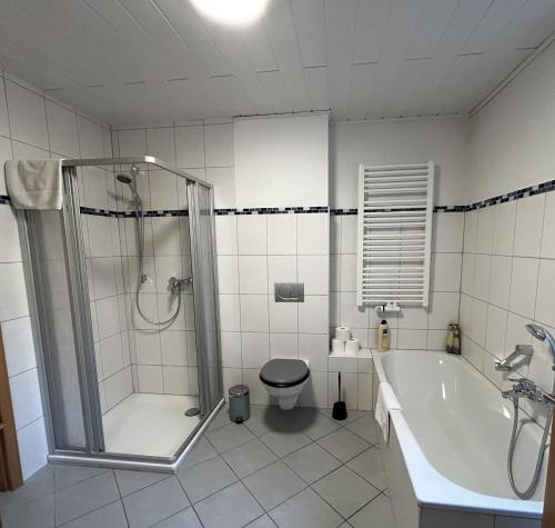 a bathroom with a shower and a tub and a toilet at FEWO Unterm Stein - Hänsel & Gretel - 2 Schlafzimmer in Alheim