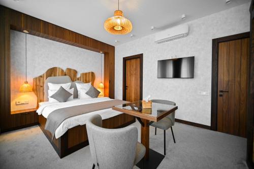 a bedroom with a bed and a table and chairs at Escapes Boutique Hotel & Restaurant in Dilijan