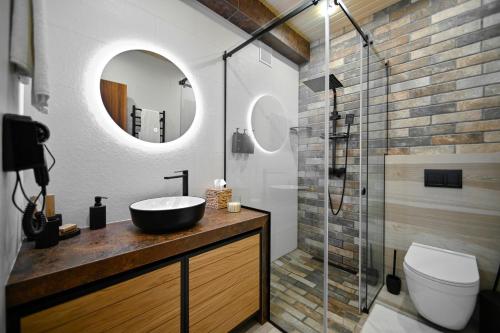 a bathroom with a sink and a glass shower at Escapes Boutique Hotel & Restaurant in Dilijan