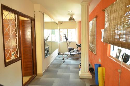 a gym with orange walls and a hallway with exercise equipment at Athasri Hotel Cubbon Road in Bengaluru