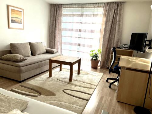 a living room with a couch and a table at Bahnhofs-und Zentrumsnahe schöne 2-Zimmer Wohnung in Landshut