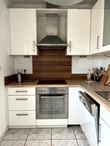 a kitchen with white cabinets and a stainless steel oven at Bahnhofs-und Zentrumsnahe schöne 2-Zimmer Wohnung in Landshut