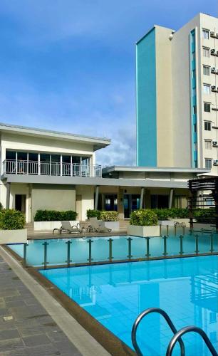 a hotel swimming pool in front of a building at DaLei 1-319 Sleeps 8pax at Marina Spatial Condominium in Dumaguete City in Dumaguete