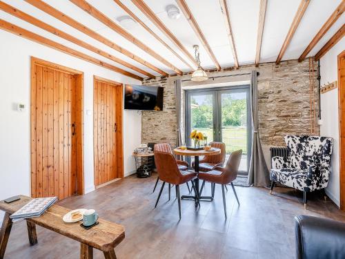 ein Wohnzimmer mit Tisch und Stühlen in der Unterkunft The Old Cowsheds 5 - Llanilar - Uk49790 in Cribyn