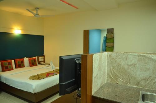a bedroom with a bed and a tv and a tvictericter at Athasri Hotel Cubbon Road in Bengaluru