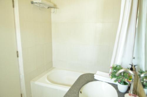 a bathroom with a sink and a bath tub at Athasri Hotel Cubbon Road in Bengaluru