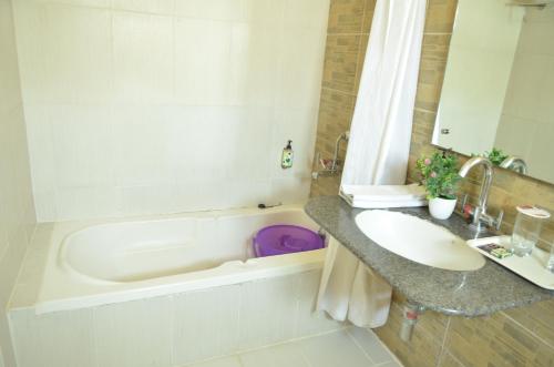 a bathroom with a sink and a bath tub and a sink at Athasri Hotel Cubbon Road in Bengaluru